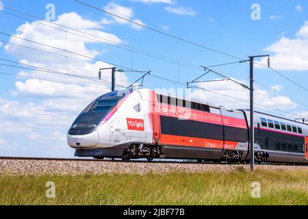 Un treno TGV Euroboduplex ad alta velocità dalla compagnia ferroviaria franco-svizzera Lyria è in auto per Parigi sulla LGV Sud-Est in campagna. Foto Stock