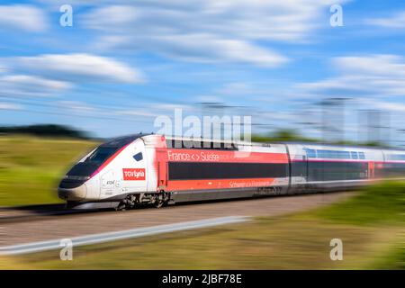 Un treno TGV Euroboduplex ad alta velocità dalla compagnia ferroviaria franco-svizzera Lyria è in viaggio a piena velocità in campagna. Foto Stock