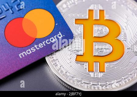 Cracovia, Polonia - Aprile 29 2022: Carta di credito Mastercard con moneta Bitcoin Foto Stock