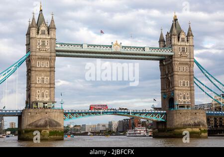 Autobus a due piani rosso che attraversa Tower Bridge, River Thames, Londra, Inghilterra, Regno Unito Foto Stock