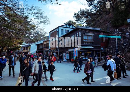 Affollata da gente locale e turisti a piedi la strada principale Itsukushima Foto Stock