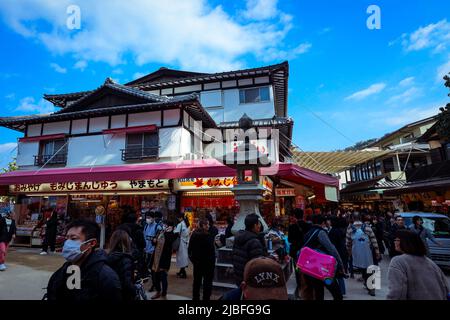 Affollata da gente locale e turisti a piedi la strada principale Itsukushima Foto Stock