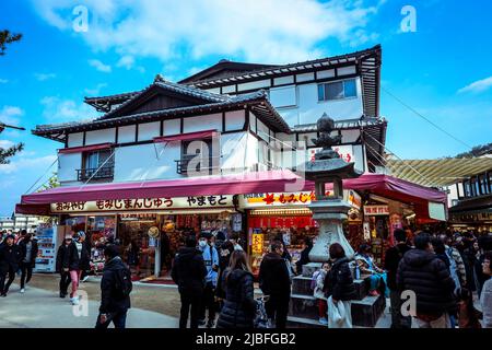 Affollata da gente locale e turisti a piedi la strada principale Itsukushima Foto Stock