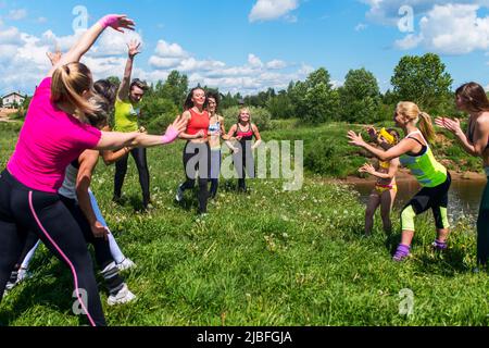 Gruppo di donne che corrono all'aperto divertendosi in natura. Foto Stock