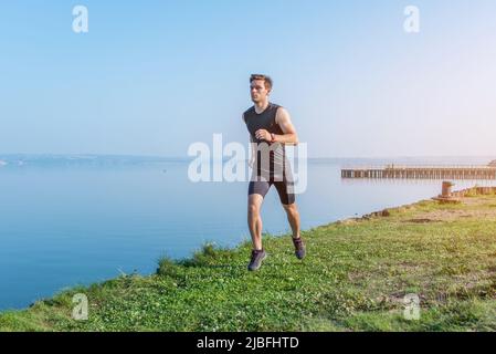 Giovane pareggiatore che corre al mattino Athlete runner allenando cardio Foto Stock