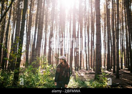 Americano africano maschio barbuto con dreadlocks e incrementato le mani di fumare il sigaro in prossimità di alberi Foto Stock