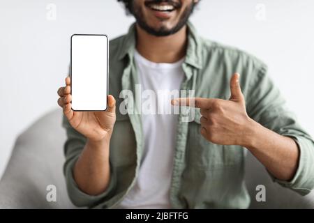 Un uomo che punta allo smartphone con uno schermo vuoto Foto Stock