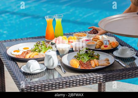 Cameriera donna che serve cibo per la colazione nel ristorante dell'hotel di lusso, resort Foto Stock