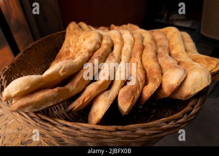 Accatastate il delizioso pane tradizionale georgiano Shoti in un cestino di vimini Foto Stock