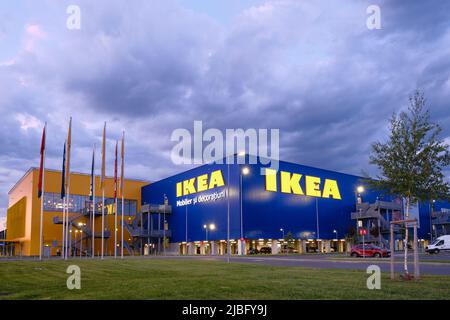 Logo IKEA e costruzione all'orario di chiusura, con spettacolari nuvole e spazio per la copia. IKEA è un rivenditore di mobili pronti per l'assemblaggio, fondato in Svezia. BU Foto Stock