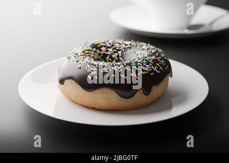 Ciambella di cioccolato su un piatto, vista ravvicinata con profondità di campo poco profonda, resa 3D. Illustrazione fotorealistica di una gustosa ciambella, sfondo scuro Foto Stock