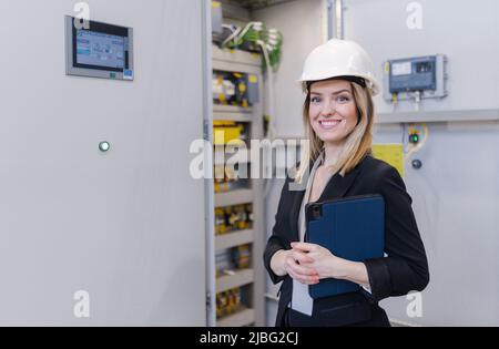 Ritratto di capo ingegnere femminile in una moderna fabbrica industriale con tablet. Foto Stock