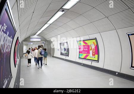 Londra, Regno Unito. Tunnel di accesso alla metropolitana alla stazione di Liverpool Street sulla nuova rete Elizabeth Line (Crossrail). Mostra il gruppo di famiglia che passa attraverso. Foto Stock