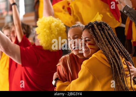 Felici gli appassionati di calcio che supporranno la squadra nazionale spagnola in una partita di calcio dal vivo allo stadio, festeggiando. Foto Stock