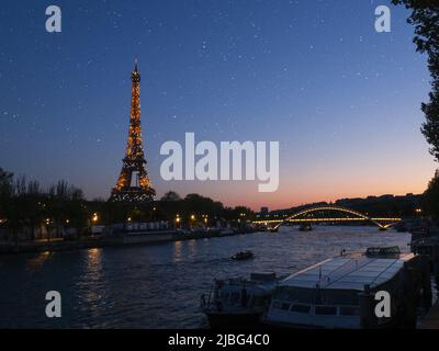 Torre eiffel illuminata al tramonto Foto Stock