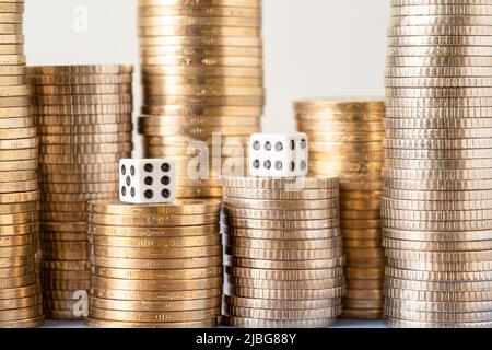 Primo piano foto di pile di monete e coppia di dices simboleggia il ruolo della fortuna ın successo. Concetto di scommessa, scommessa e lotteria. Foto Stock