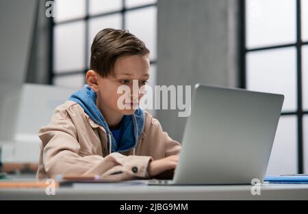 Ritratto di schoolboy usando il computer in aula a scuola Foto Stock