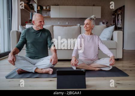 Coppia anziana che fa l'esercitazione di rilassamento insieme nel paese. Foto Stock