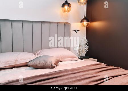 Elegante camera da letto interna. Letto grande e comodo per rilassarsi. Design minimalista, colori alla moda. Foto Stock