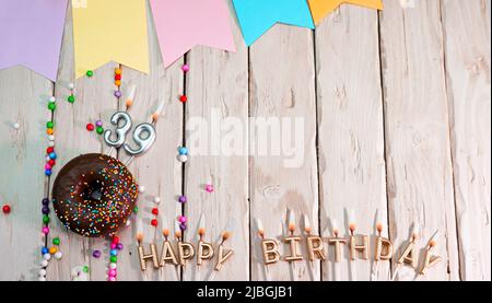 Compleanno con numero. Ciambella sul tavolo delle feste. Buon compleanno complimenti vista dall'alto. Buon compleanno carta con belle decorazioni su un bianco Foto Stock