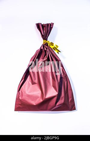 Due grandi buste regalo con nota di ringraziamento i tag di testo sulla  sedia tavolo in camera isolata, giallo dorato carta di avvolgimento dalla  finestra a parete closeup Foto stock - Alamy