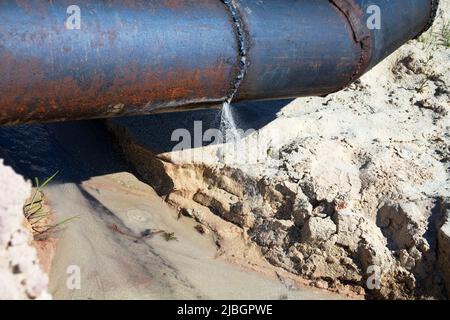 L'acqua si è rotta attraverso un tubo dell'acqua di ferro (rete dell'acqua bruciata). Mancanza di risparmio di acqua, perdita di acqua potabile Foto Stock