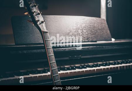 Chitarra e pianoforte elettronico in una stanza buia da vicino. Foto Stock