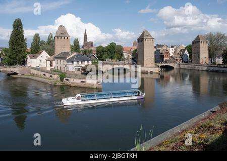 Vista della storica città vecchia Petite France sul fiume Ill, torri, ponti coperti e canali con barca turistica a Strassburg come visto dal Barrage Foto Stock