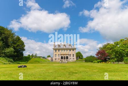 Lato della Kingston Lacy Country House con rasaerba robotizzato di Husqvarna automower taglio dell'erba in una giornata di sole estati con Union Jack bandiera volare Foto Stock