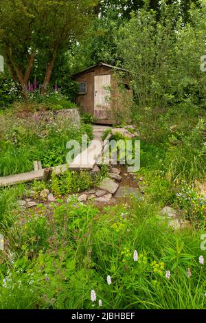 Un passaggio panoramico in legno e pelle attraverso un prato di ruscello e paludi in Un paesaggio della Gran Bretagna vincitore del premio Best Show Garden Award Foto Stock