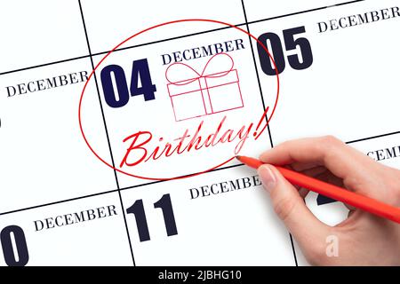 4th dicembre. La mano cerchia la data sul calendario 4 dicembre, disegna una scatola regalo e scrive il testo compleanno. Vacanza. Mese invernale, giorno o Foto Stock