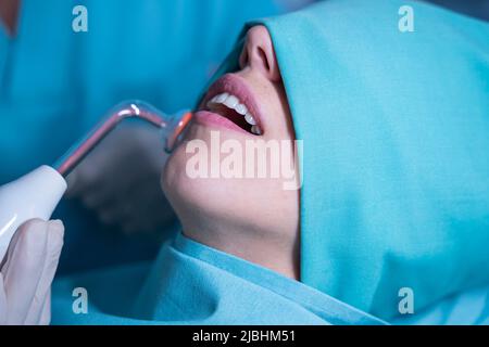 Paziente sottoposto a trattamento odontoiatrico con ozono in clinica Foto Stock