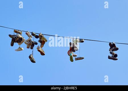 Kaliningrad, Russia – 11 settembre 2016: Sneakers sportivi appesi su un filo elettrico contro il cielo. Foto Stock