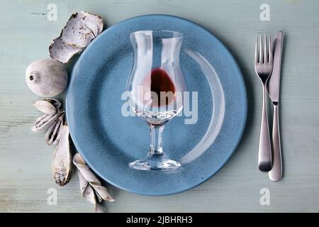 Piatto blu con bicchiere di vino e spezie esotiche e frutta su tavola di legno blu chiaro. Disposizione piatta Foto Stock