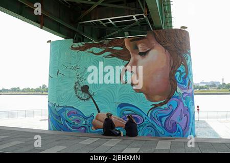 Le ragazze chiacchierano a Belgrado accanto alla Street art dipinta sotto il Ponte Vecchio Sava Foto Stock