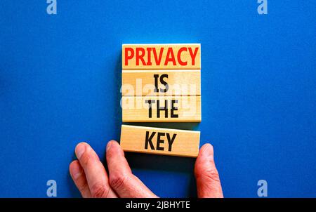 Privacy è il simbolo chiave. Concetto parole Privacy è la chiave su blocchi di legno su una bella tabella blu sfondo blu. Mano dell'uomo d'affari. Business, fi Foto Stock