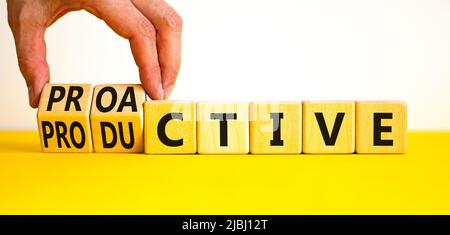 Simbolo proattivo e produttivo. L'uomo d'affari trasforma i cubi e cambia la parola di concetto produttiva a Proactive. Bellissimo sfondo bianco. pr. Commerciale Foto Stock