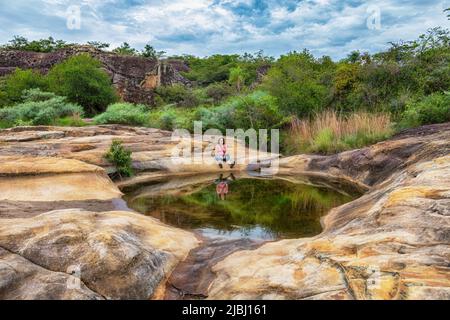 Sulla strada per l'arco di roccia si passa la laguna specchio dell'altopiano roccioso di Cerro Arco a Tobati, Paraguay. Foto Stock