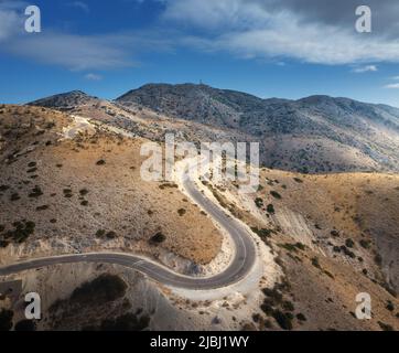 Vista aerea della tortuosa strada di montagna, cielo blu all'alba Foto Stock