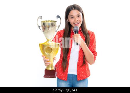 Ragazza adolescente che tiene un microfono trofeo discorso. Bambino vincitore del capretto ha vinto il concorso, celebrando il successo e la vittoria, premio di conquista. Ritratto di Foto Stock