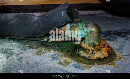 Perdita d'acqua nel tubo dell'acqua calda in rame corroso di una bombola dell'acqua calda, Aotearoa / Nuova Zelanda. Foto Stock