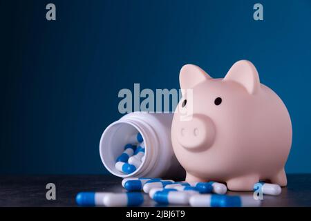 Piggy banca e farmaci. Pillole di acquisto. Credito per il trattamento. Mancanza di fondi per i servizi medici. Foto Stock