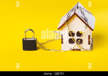 Arresto dell'alloggiamento. Casa del castello. Piccola casa giocattolo e una catena con un lucchetto. Foto Stock