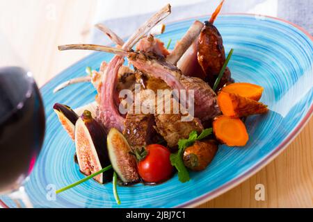 Costolette di montone arrosto con fichi, verdure, demi-glace e vino rosso Foto Stock