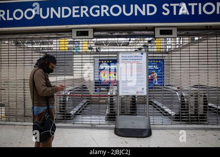 Un uomo è visto controllare il suo viaggio sul suo cellulare di fronte all'ingresso chiuso della stazione della metropolitana di Waterloo. La stazione di Waterloo è più trafficata del solito alle ore di punta a causa dello sciopero della metropolitana di Londra. I conducenti della metropolitana di Londra provenienti dalla Rail, Maritime, and Transport Union (RMT) sono in sciopero sulla disputa sulla perdita di pensioni e posti di lavoro. Oltre 4000 collaboratori hanno partecipato alla passeggiata nella maggior parte delle stazioni della zona 1 a Londra. Decine di migliaia di londinesi sono colpiti e devono utilizzare mezzi di trasporto alternativi per spostarsi al lavoro. Foto Stock