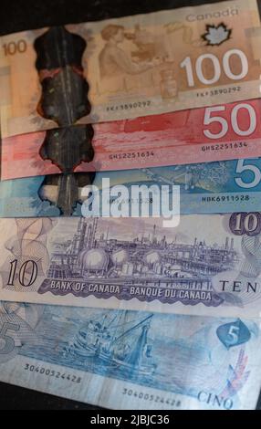 Toronto, Canada - Ottobre 30. 2021: Una vecchia banconota canadese con nuove banconote in polimero CAD. Scene del Canada con la raffineria dell'olio raffigurata e di nuovo colore Foto Stock