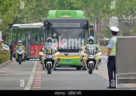 YANTAI, CINA - 7 GIUGNO 2022 - i poliziotti del traffico scortano gli autobus che trasportano gli allievi per l'esame nazionale dell'entrata dell'università (GAOKAO) in Laishan dist Foto Stock