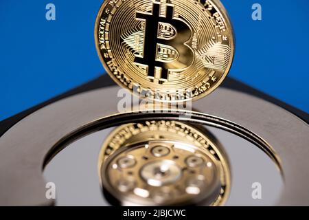 Bitcoin che si riflette sul disco rigido. Tecnologia digitale e concetto di blockchain. Bitcoin d'oro sulla parte superiore dell'HDD. Foto Stock