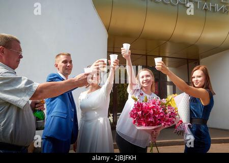 Kirov, RUSSIA - 10 agosto 2021: Sposi e sposi presso l'ufficio del registro dopo la cerimonia ufficiale del matrimonio e persone, amici, parenti, ospiti co Foto Stock