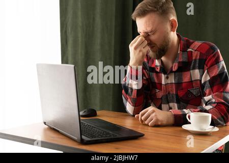 l'uomo d'affari caucasico lavora fuori orario e sente gli occhi stanchi in ufficio, massaggiando il ponte del naso dolore oculare, problemi di vista Foto Stock